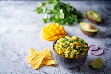 Mango Guacamole with corn chips and ingredients to prepare it