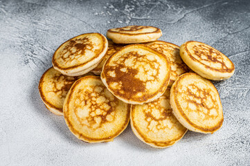 Fototapeta na wymiar Stack of buttered pancakes on a kitchen table. White background. Top View
