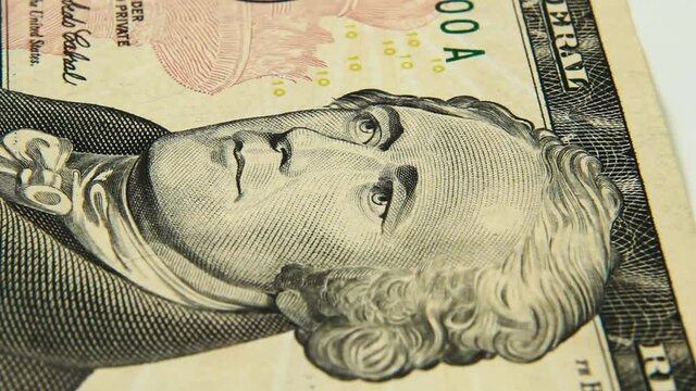 Cash money background. Alexander Hamilton portrait on 10 US dollar bill close up rotation