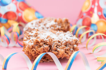 Traditional Finnish May Day funnel cake (tippaleipa) with a streamer on the pink background. Close...