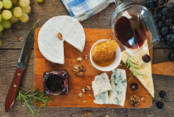 Cheese plate served with wine, jam and grapes. Top view.