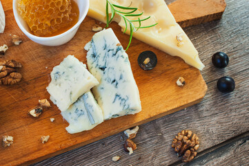 Cheese plate served with honey and grapes. Top view.