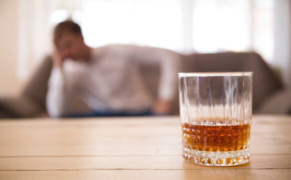Glass of whiskey on wooden table. Alcohol. Family problem. Whiskey. 