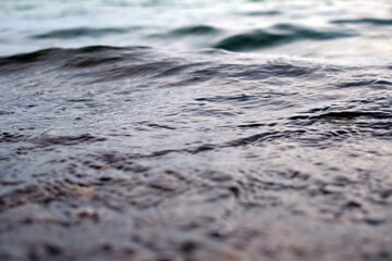 Water surface with ripples and sunrays reflections