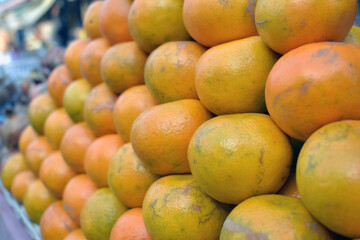 Closeup shot of a pile of fresh oranges in a market place