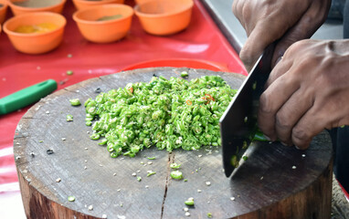 Chaf slicing Chili pepper with Knife on wooden board