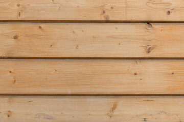The facade of the house is made of new horizontal wooden boards. Wooden texture