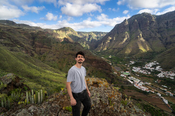 Naklejka na ściany i meble young man contemplates the landscape. Agaete valley. Gran Canaria