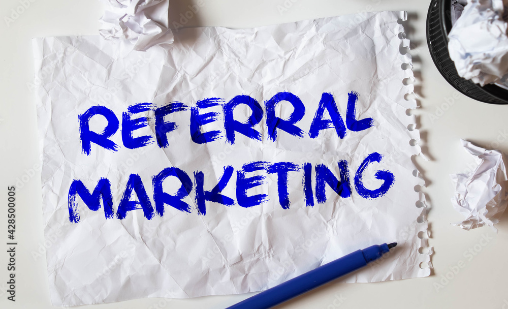 Poster directly above view of office table workspace with referral marketing text