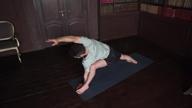 Caucasian Yoga Instructor Is Performing Yoga Pose At Home. Attractive Man Making Yoga Pose. 