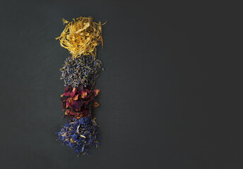 Top view of floral herbs - dried marigold, lavender, rose and cornflower petals as ingredients for cooking