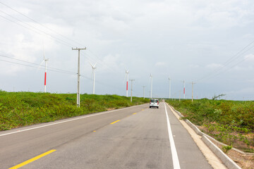 Estrada corta deserto com geração de energia sustentável.