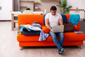 Young man student preparing for trip at home