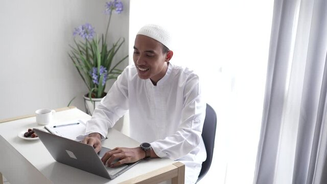 happy asian muslim man meeting using laptop for video call conference