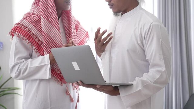 two muslim business partner discussing and meeting using laptop together