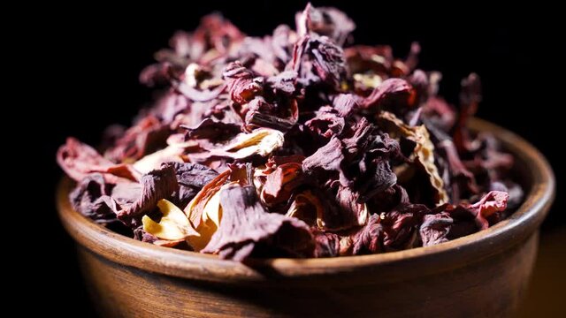 Dry hibiscus flowers tea rotation texture background from Sudanese rose, karkade.
