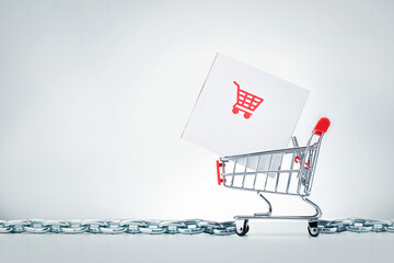 Supply chain management SCM. Parcel box in shopping cart on grey background with copy space.