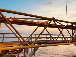 Silhouette of structure of the bridge in offshore platform in sun set at the sea.