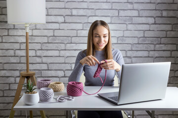 Pretty woman is learning how to knit online. Adult age female vlogge. The development of new...