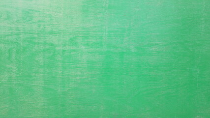 Green cement wall background. A concrete wall that is unevenly colored with some reflection.