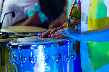 Closeup shot of a man playing drums at the carnival at night