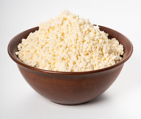 Cottage cheese on a white background. Homemade cottage cheese in a deep plate. Milk product