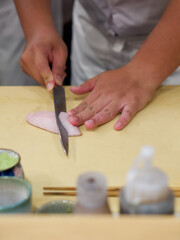 Chef use sharp knife slicing Aburi white fish for sashimi. Enjoy Omakase experience at Japanese Sushi Restaurant.