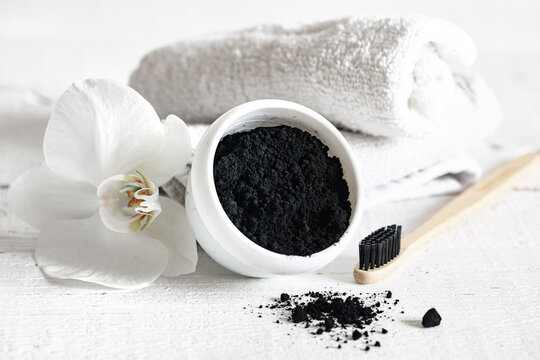 Close up of black natural teeth whitening powder and toothbrush.
