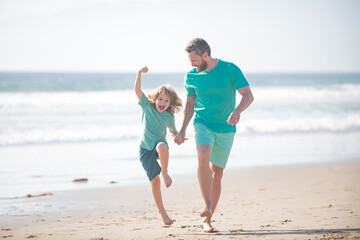 Father and son running on summer beach. Dad and child enjoying outdoor.