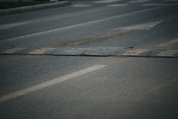 Closeup shot of a bolted down traffic safety speed bump on an asphalt road