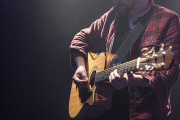 Obraz premium Acoustic guitar in the hands of a guitarist.