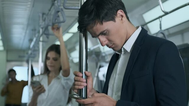 working young man with a smartphone on the train in the middle of the night