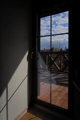 View through the window on a balcony with a wooden balustrade 