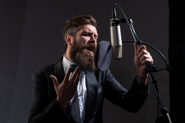 Man with microphone singing in music hall.