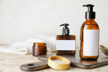 Bottles with natural shampoo on light background