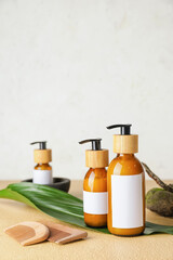 Bottles with natural shampoo and combs on color background