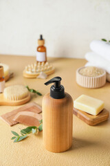 Bottle with natural shampoo, combs and soap on color background