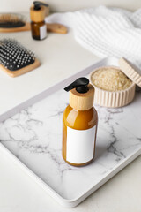 Bottle with natural shampoo on light background