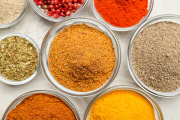 Bowls with different spices on light background