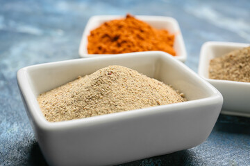 Bowl with pepper powder on color background, closeup