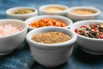 Bowls with different spices on color background, closeup