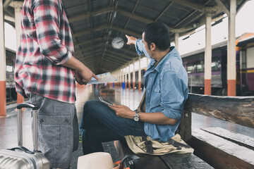 Tourist with backpack wait for train and ask for direction help.