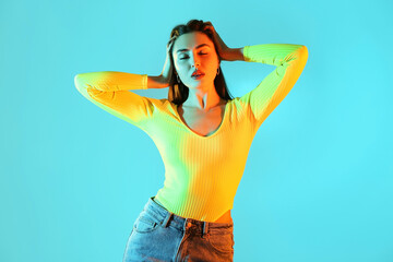 Toned portrait of beautiful young woman on color background