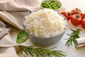 Bowl with tasty rice on light wooden background
