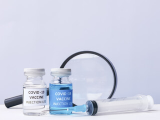 Selective focus vaccines jar with syringe and magnifying glass. Development and research of vaccine COVID-19. 