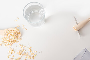 Step by step recipe. Cooking oat vegetable milk. Step 1 Ingredients: glass of water, oatmeal flakes, blender. Homemade food concept. Plant based organic veggie milk, lactose free