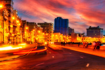 Sunset in Havana with old buildings and traffic along the Malecon wall - Long exposure. Unrecognizable people