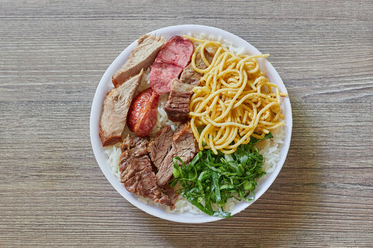 Marmitex With White Rice, Beans, Cabbage, Pasta And Barbecue With Side Dish Of Cabbage, Crumbs And Gnocchi On A Textured Wooden Table - Top View.