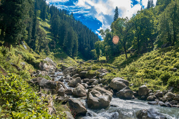 Fototapeta na wymiar Landscape in the mountains. The beautiful river flowing between alpine meadows in the lap of Himalaya, Parvati valley. Trek to Hamta Pass, 4270 m, Himachal Pradesh, India.
