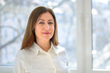 Thoughtful middle-aged woman looking at the camera with a quiet smile